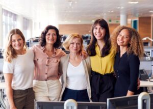 Five women in a corporate/office setting